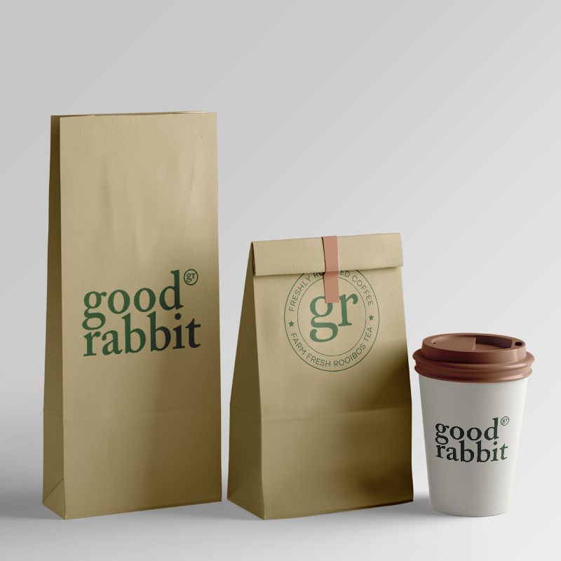 Two craft coffee pouches and a disposable cardboard cup with a plastic lid, perfect for on-the-go coffee lovers