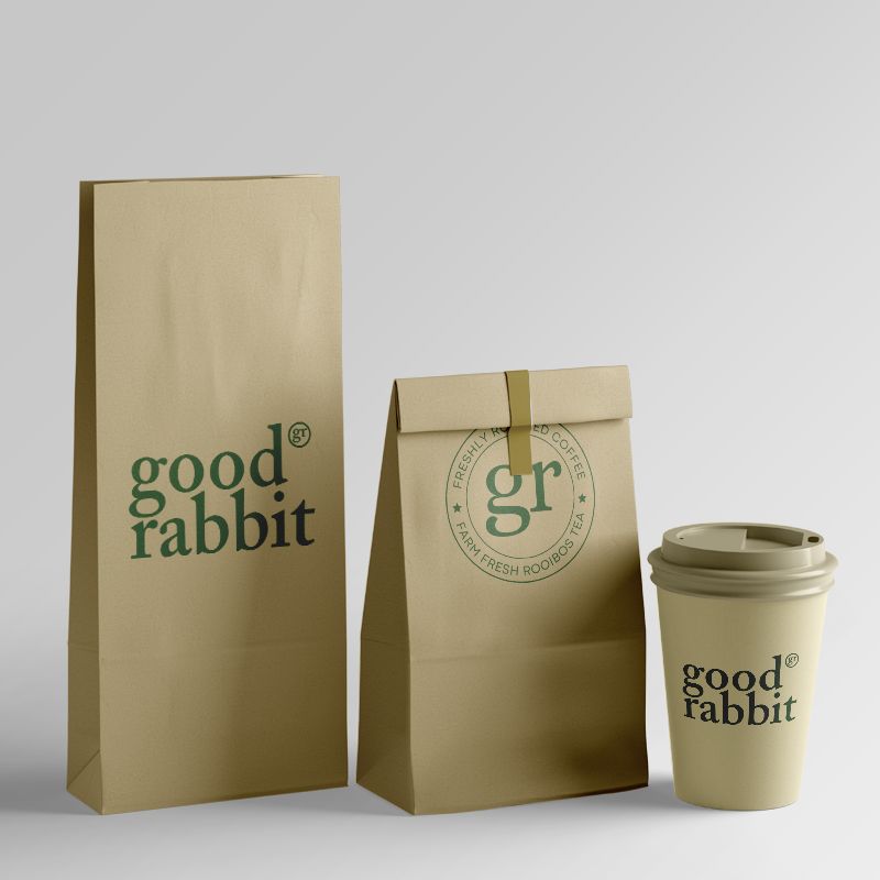 Two craft coffee pouches and a disposable cardboard cup with a plastic lid, featuring a delightful medium-roasted two-bean coffee blend